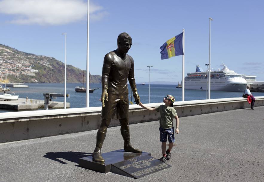 Un fan con la statua di Cristiano Ronaldo a Funchal (Ap)
